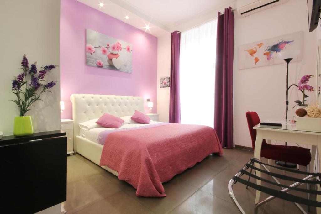 Quarto do Vatication B&B, em Roma, decorado em tons de rosa e lilás.
