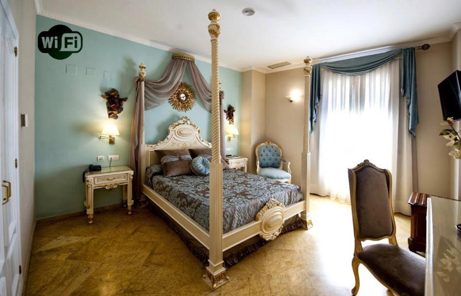 Quarto de hotel luxuoso com cama de dossel e móveis dourados no Adriano Boutique Sevilla em Sevilha.