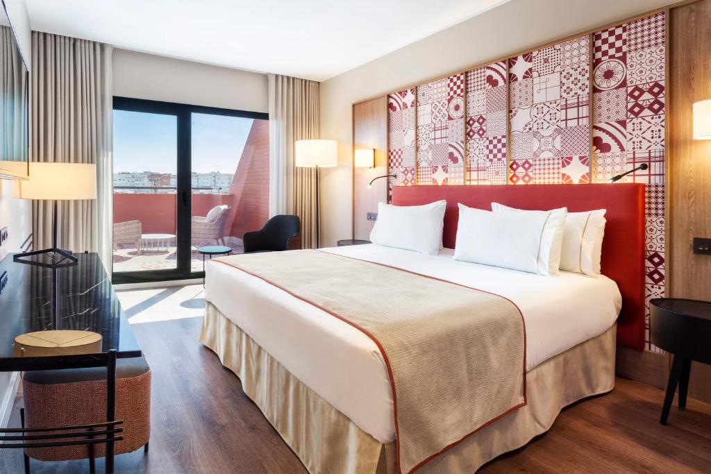 Quarto de hotel moderno com varanda no Eurostars Guadalquivir em Sevilha.