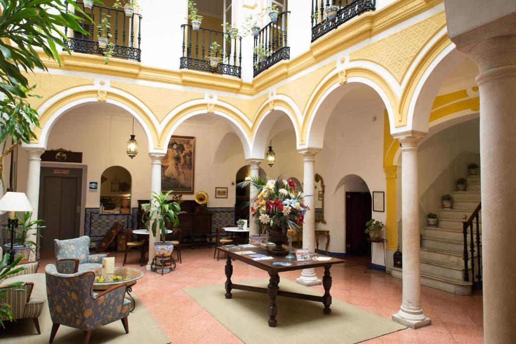 Pátio interno tradicional com arcos e colunas no Hotel Abanico Casa Palacio em Sevilha.