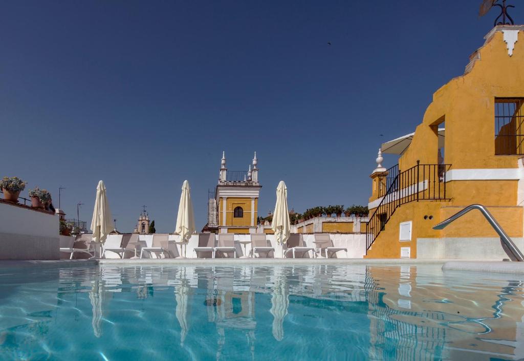 Piscina na cobertura de hotel com vista para torres no Hotel Las Casas de la Judería em Sevilha.