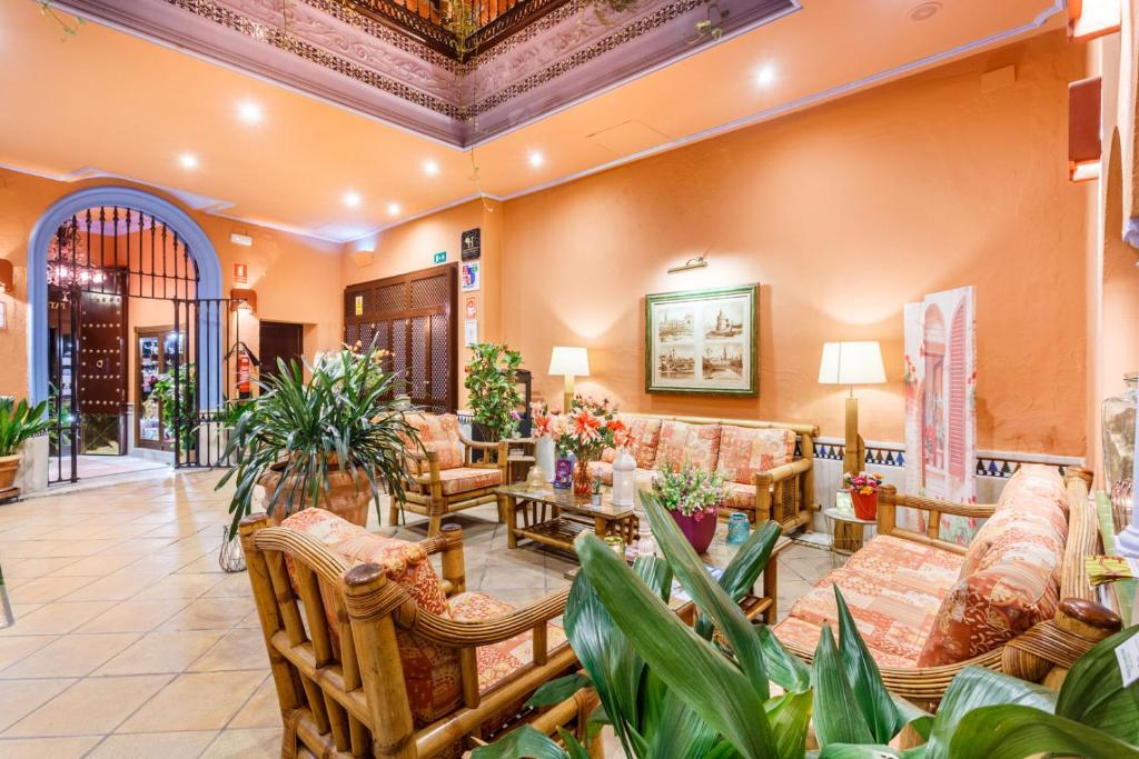 Lounge de hotel com móveis de bambu e plantas no Patio de la Alameda em Sevilha.
