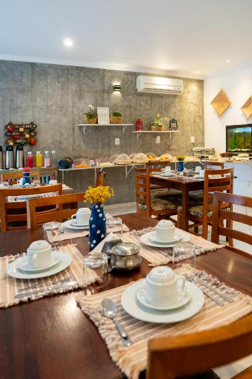 Sala de café da manhã da Pousada Luar do Prata, em Trindade, com mesas postas e buffet.