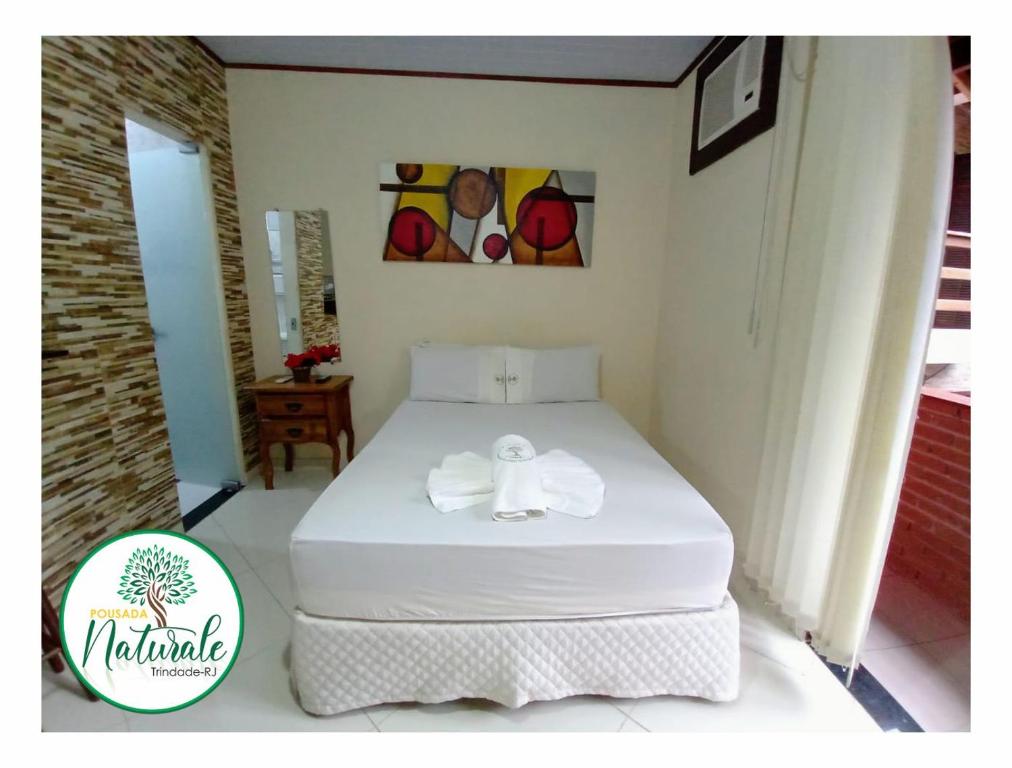 Quarto da Pousada Naturale, em Trindade, com cama de casal, ar-condicionado e varanda lateral.